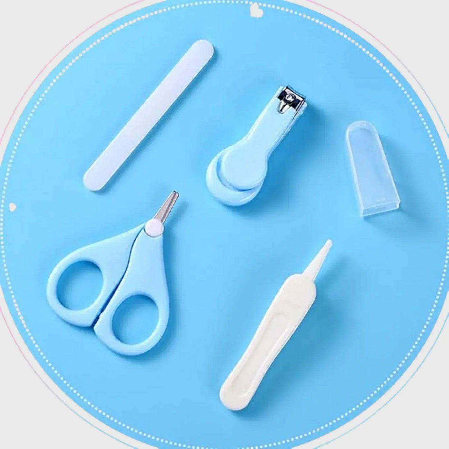 Baby grooming kit with nail clippers, scissors, file and nasal aspirator on blue background