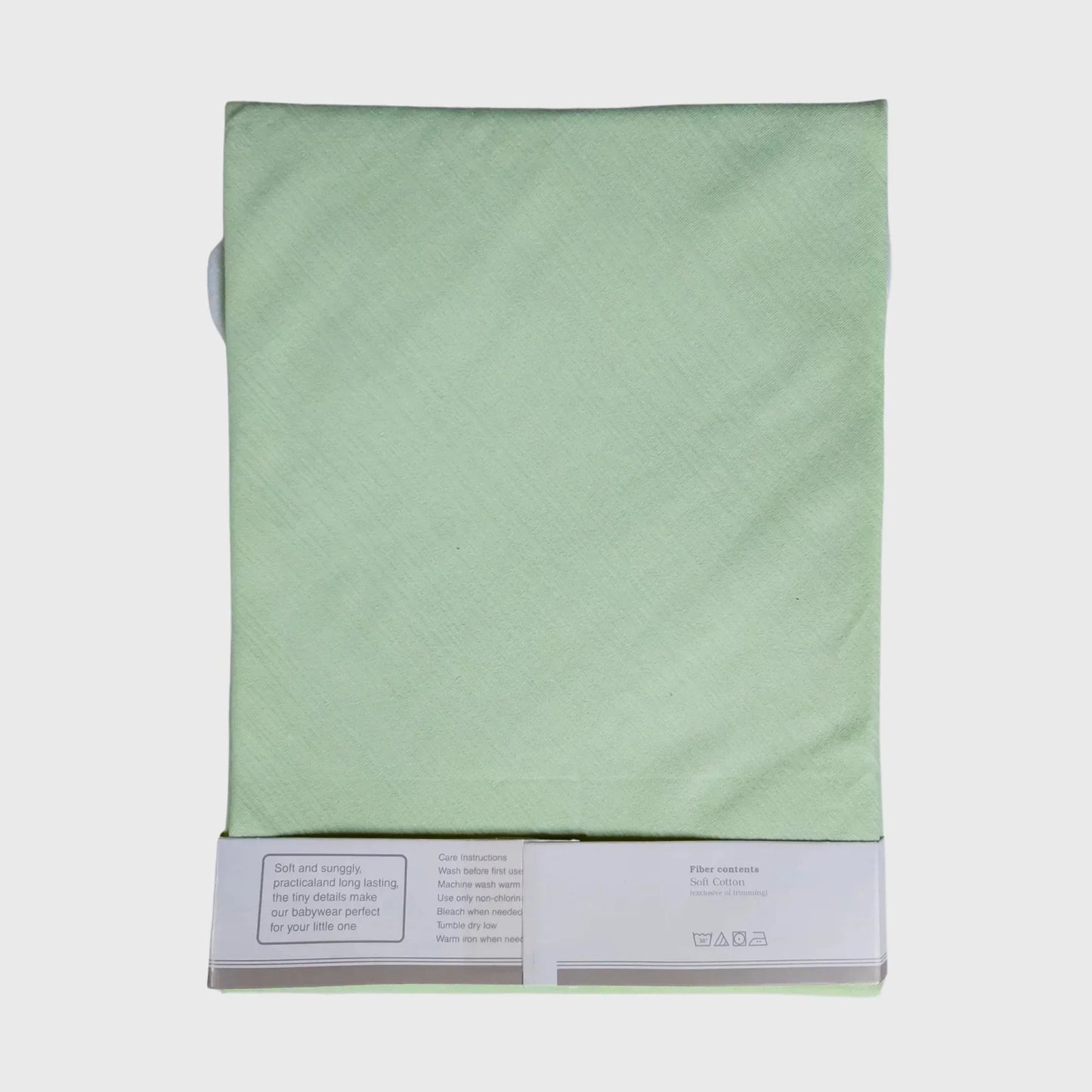 Light green soft cotton fabric for baby clothing, displayed folded with care instructions visible