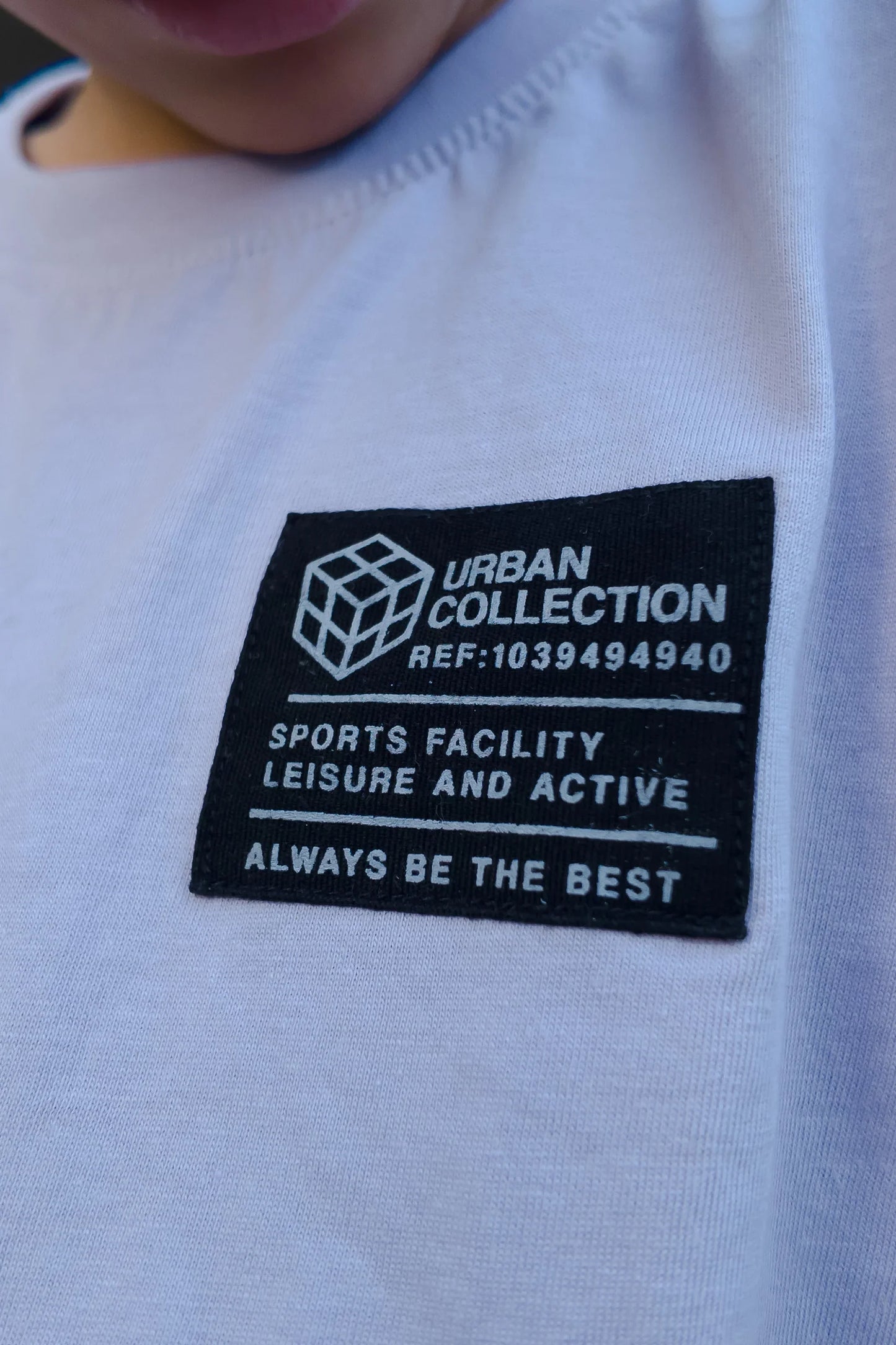 Close-up of a child's light blue t-shirt with a black 'Urban Collection' patch.