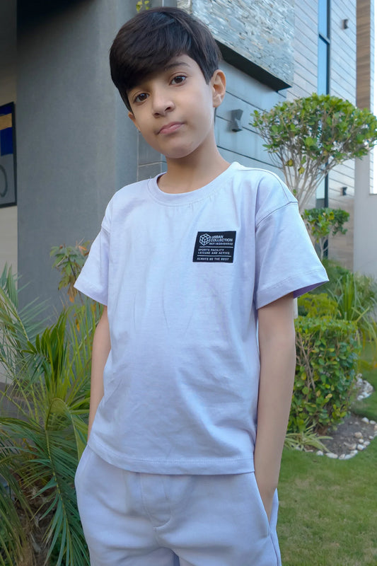 Boy wearing a light blue casual t-shirt and shorts set outdoors, kids fashion outfit
