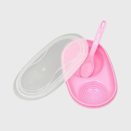 Pink baby feeding bowl with lid and matching spoon on white background